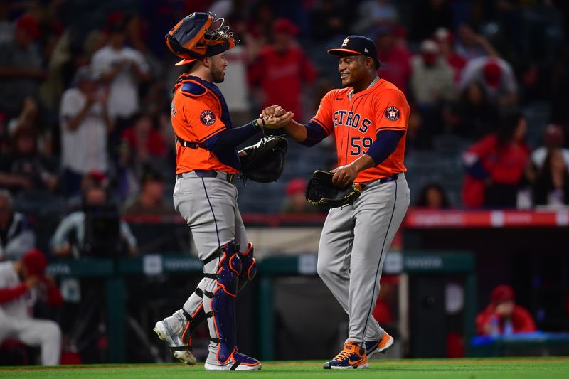 Jun 7, 2024; Anaheim, California, USA; Houston Astros catcher Victor Caratini (17) and pitcher Framber Valdez (59) celebrate the victory against the Los Angeles Angels at Angel Stadium. Mandatory Credit: Gary A. Vasquez-USA TODAY Sports