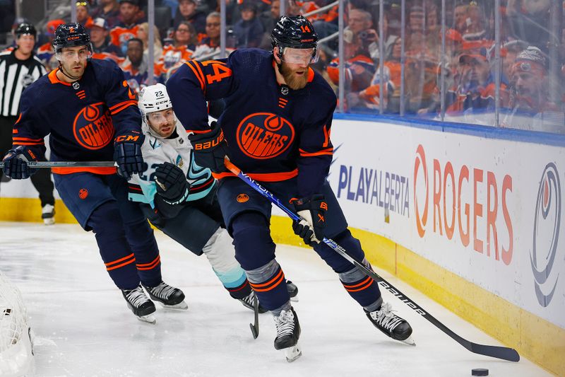 Jan 18, 2024; Edmonton, Alberta, CAN; e. defensemen Mattias Ekholm (14) clears the puck in front of Seattle Kraken forward Oliver Bjorkstrand (22) during the second period at Rogers Place. Mandatory Credit: Perry Nelson-USA TODAY Sports