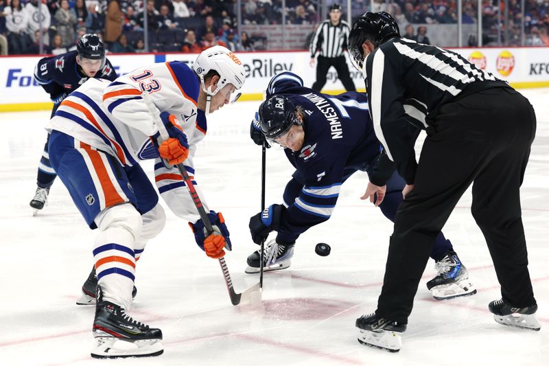 Apr 13, 2025; Winnipeg, Manitoba, CAN; Edmonton Oilers center Mattias Janmark (13) and Winnipeg Jets center Vladislav Namestnikov (7) face off in the second period at Canada Life Centre. Mandatory Credit: James Carey Lauder-Imagn Images