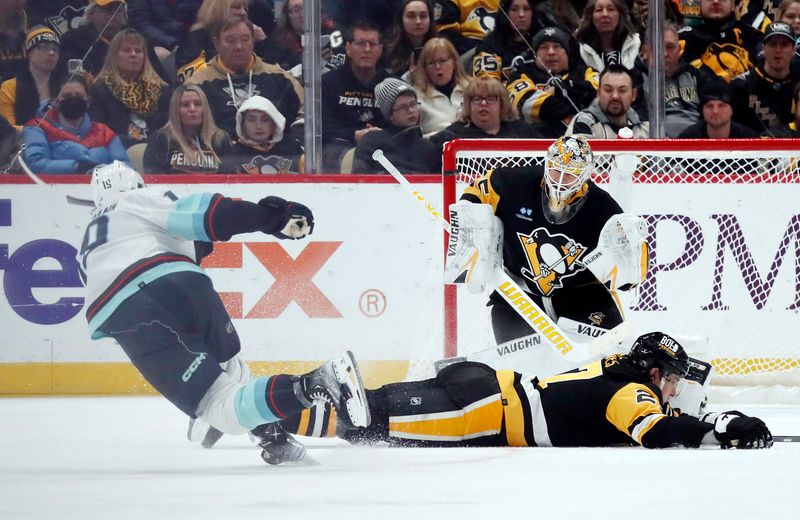 Jan 15, 2024; Pittsburgh, Pennsylvania, USA; Pittsburgh Penguins goaltender Tristan Jarry (35) makes a save against Seattle Kraken left wing Jared McCann (left) as Pens defenseman Ryan Graves (27) defends during the third period at PPG Paints Arena. Mandatory Credit: Charles LeClaire-USA TODAY Sports