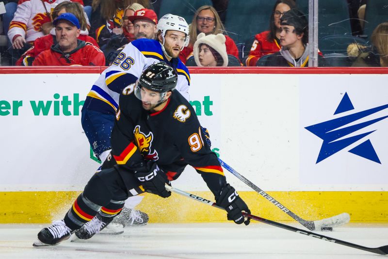 Jan 23, 2024; Calgary, Alberta, CAN; St. Louis Blues left wing Nathan Walker (26) controls the puck against Calgary Flames center Nazem Kadri (91) during the first period at Scotiabank Saddledome. Mandatory Credit: Sergei Belski-USA TODAY Sports