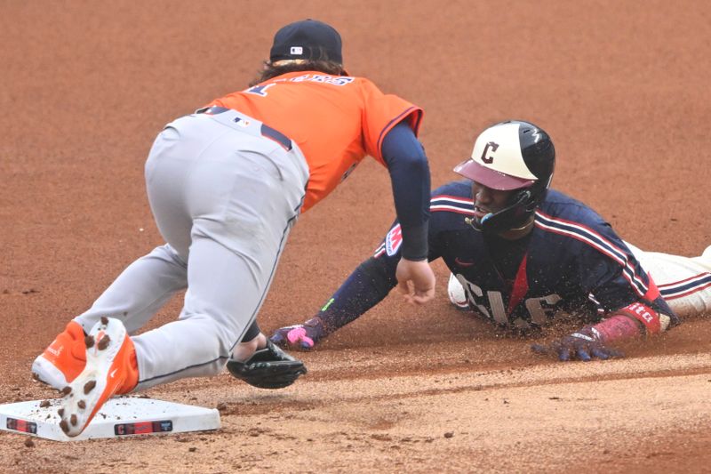 Jun 6, 2025; Cleveland, Ohio, USA; Cleveland Guardians center fielder Angel Martinez (1) is tagged out by Houston Astros second baseman Brendan Rodgers (1) while trying to stretch a single in the first inning at Progressive Field. Mandatory Credit: David Richard-Imagn Images