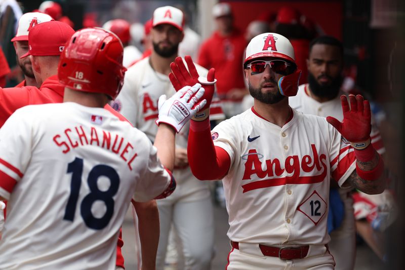 Jun 9, 2024; Anaheim, California, USA;  Los Angeles Angels right fielder Kevin Pillar (12) is greeted by first baseman Nolan Schanuel (18) after scoring a run on a sacrifice fly bySchanuel during the second inning against the Houston Astros at Angel Stadium. Mandatory Credit: Kiyoshi Mio-USA TODAY Sports