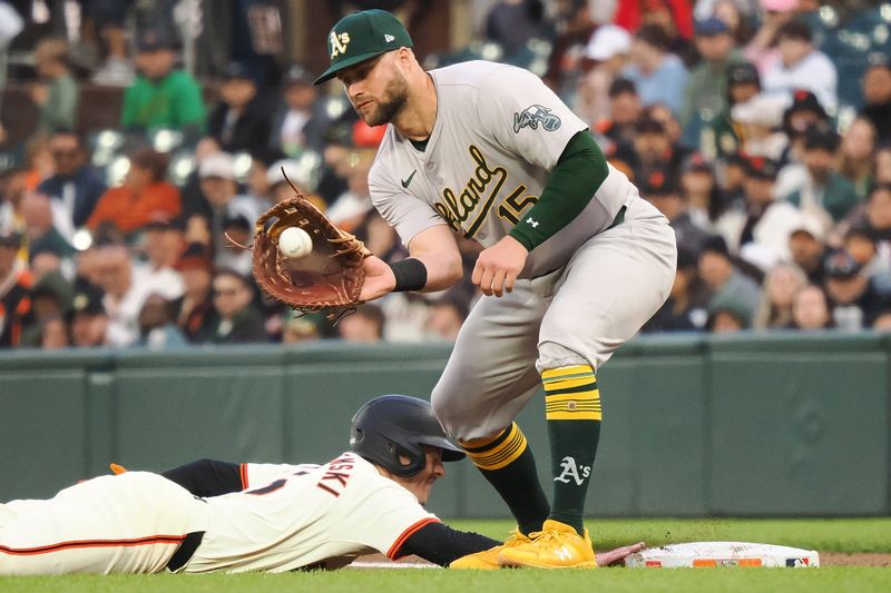 Jul 31, 2024; San Francisco, California, USA; San Francisco Giants right fielder Mike Yastrzemski (5) dives safely back to first base against Oakland Athletics first baseman Seth Brown (15) during the fifth inning at Oracle Park. Mandatory Credit: Kelley L Cox-USA TODAY Sports