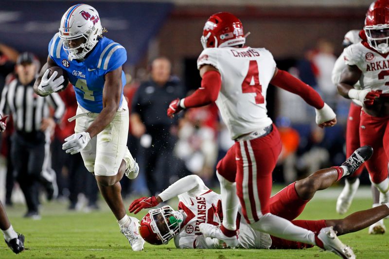 Oct 7, 2023; Oxford, Mississippi, USA; Mississippi Rebels running back Quinshon Judkins (4) runs the ball as Arkansas Razorbacks defensive back Jayden Johnson (8) makes the tackle during the second half at Vaught-Hemingway Stadium. Mandatory Credit: Petre Thomas-USA TODAY Sports