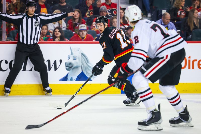 Jan 27, 2024; Calgary, Alberta, CAN; Calgary Flames center Mikael Backlund (11) controls the puck against the Chicago Blackhawks during the second period at Scotiabank Saddledome. Mandatory Credit: Sergei Belski-USA TODAY Sports