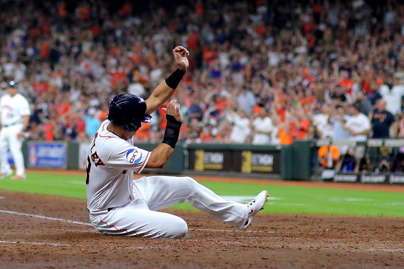 Sep 13, 2023; Houston, Texas, USA; Houston Astros designated hitter Michael Brantley (23) slides across home plate to score a run against the Oakland Athletics during the fifth inning at Minute Maid Park. Mandatory Credit: Erik Williams-USA TODAY Sports