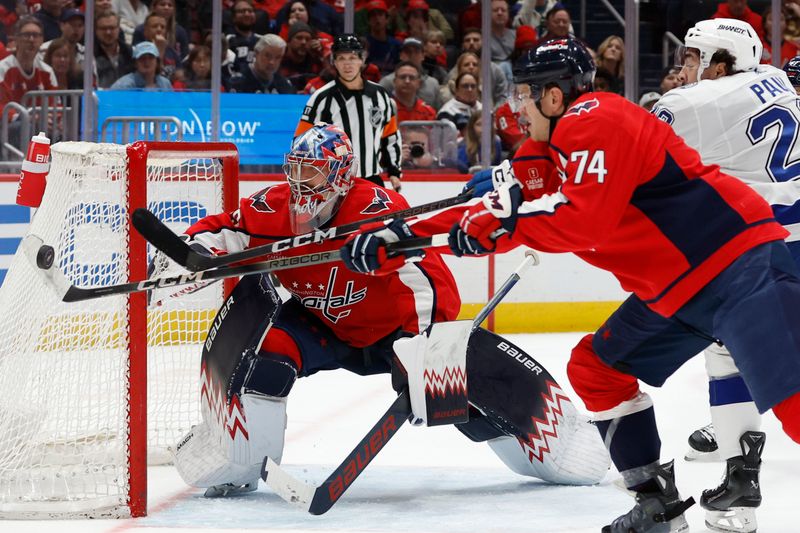 Apr 13, 2024; Washington, District of Columbia, USA; Washington Capitals defenseman John Carlson (74) and Tampa Bay Lightning left wing Nicholas Paul (20) attempt to bat the puck out of the air in front of Capitals goaltender Charlie Lindgren (79) in the second period at Capital One Arena. Mandatory Credit: Geoff Burke-USA TODAY Sports