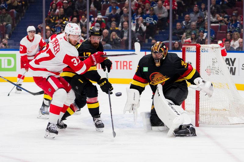 Feb 15, 2024; Vancouver, British Columbia, CAN; Detroit Red Wings forward J.T. Compher (37) and Vancouver Canucks defenseman Filip Hronek (17) and goalie Thatcher Demko (35) follow the rebound in the first period at Rogers Arena. Mandatory Credit: Bob Frid-USA TODAY Sports