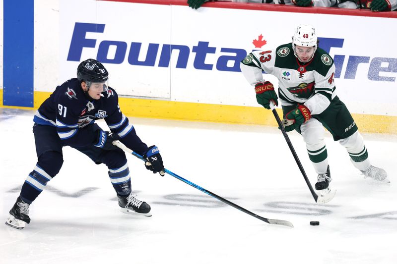 Dec 27, 2025; Winnipeg, Manitoba, CAN; Winnipeg Jets center Cole Perfetti (91) and Minnesota Wild defenseman Quinn Hughes (43) chase for the puck in the second period at Canada Life Centre. Mandatory Credit: James Carey Lauder-Imagn Images