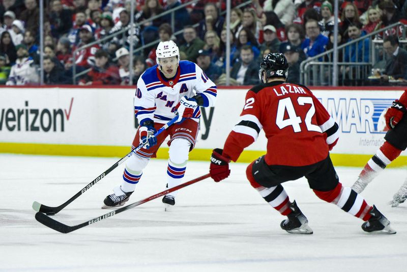 Feb 22, 2024; Newark, New Jersey, USA; New York Rangers left wing Artemi Panarin (10) skates with the puck while being defended by New Jersey Devils center Curtis Lazar (42) during the first period at Prudential Center. Mandatory Credit: John Jones-USA TODAY Sports