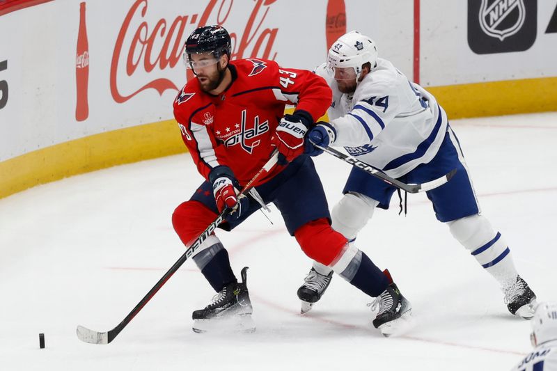 Oct 24, 2023; Washington, District of Columbia, USA; Washington Capitals right wing Tom Wilson (43) skates with the puck as Toronto Maple Leafs defenseman Morgan Rielly (44) defends in the third period at Capital One Arena. Mandatory Credit: Geoff Burke-USA TODAY Sports