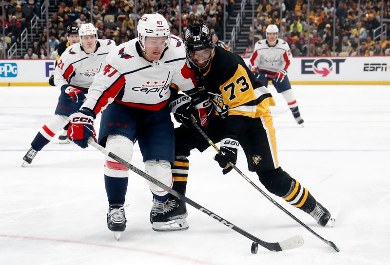 Jan 2, 2024; Pittsburgh, Pennsylvania, USA;  Washington Capitals left wing Beck Malenstyn (47) over the puck against Pittsburgh Penguins defenseman Pierre-Olivier Joseph (73) during the second period at PPG Paints Arena. Mandatory Credit: Charles LeClaire-USA TODAY Sports