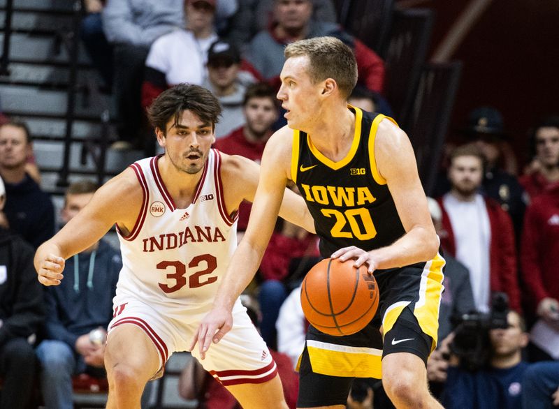 Jan 30, 2024; Bloomington, Indiana, USA; Iowa Hawkeyes forward Payton Sandfort (20) dribbles the ball while Indiana Hoosiers guard Trey Galloway (32) defends in the first half at Simon Skjodt Assembly Hall. Mandatory Credit: Trevor Ruszkowski-USA TODAY Sports