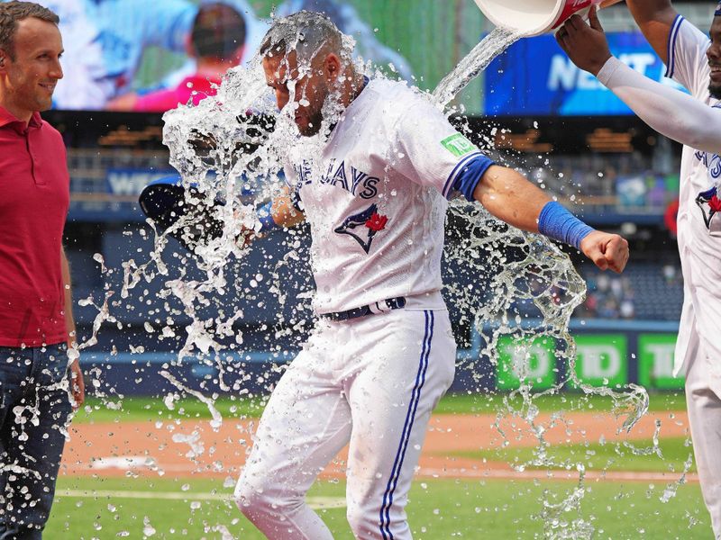 Jul 16, 2023; Toronto, Ontario, CAN; Toronto Blue Jays first baseman Vladimir Guerrero Jr. (27) pours the water bucket on center fielder Kevin Kiermaier (39) at the end of the ninth inning against the Arizona Diamondbacks at Rogers Centre. Mandatory Credit: Nick Turchiaro-USA TODAY Sports