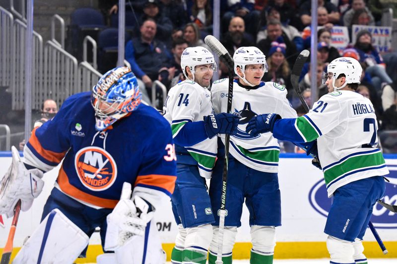 Dec 19, 2025; Elmont, New York, USA; Vancouver Canucks center David Kampf (64) celebrates with teammates after scoring a goal against the New York Islanders during the first period at UBS Arena. Mandatory Credit: John Jones-Imagn Images