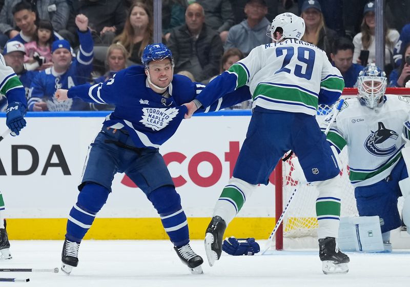 Jan 10, 2026; Toronto, Ontario, CAN; Toronto Maple Leafs center Max Domi (11) fights with Vancouver Canucks defenseman Marcus Pettersson (29) during the second period at Scotiabank Arena. Mandatory Credit: Nick Turchiaro-Imagn Images