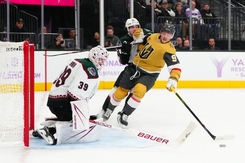 Nov 25, 2023; Las Vegas, Nevada, USA; Vegas Golden Knights center Jack Eichel (9) is held by Arizona Coyotes defenseman Sean Durzi (50) in front of Arizona goaltender Connor Ingram (39) during the first period at T-Mobile Arena. Mandatory Credit: Stephen R. Sylvanie-USA TODAY Sports