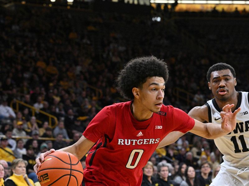 Jan 6, 2024; Iowa City, Iowa, USA; Rutgers Scarlet Knights guard Derek Simpson (0) goes to the basket as Iowa Hawkeyes guard Tony Perkins (11) defends during the first half at Carver-Hawkeye Arena. Mandatory Credit: Jeffrey Becker-USA TODAY Sports