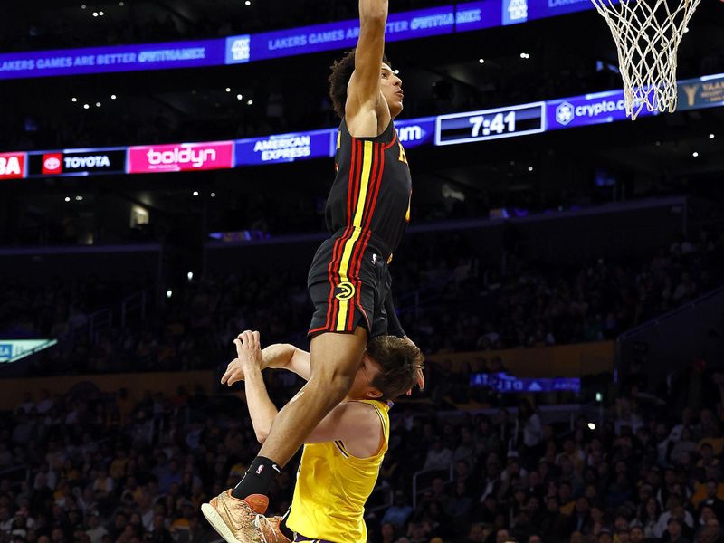 LOS ANGELES, CALIFORNIA - MARCH 18: Jalen Johnson #1 of the Atlanta Hawks makes the slam dunk and fouled by Austin Reaves #15 of the Los Angeles Lakers in the first half at Crypto.com Arena on March 18, 2024 in Los Angeles, California. NOTE TO USER: User expressly acknowledges and agrees that, by downloading and/or using this photograph, user is consenting to the terms and conditions of the Getty Images License Agreement. (Photo by Ronald Martinez/Getty Images)