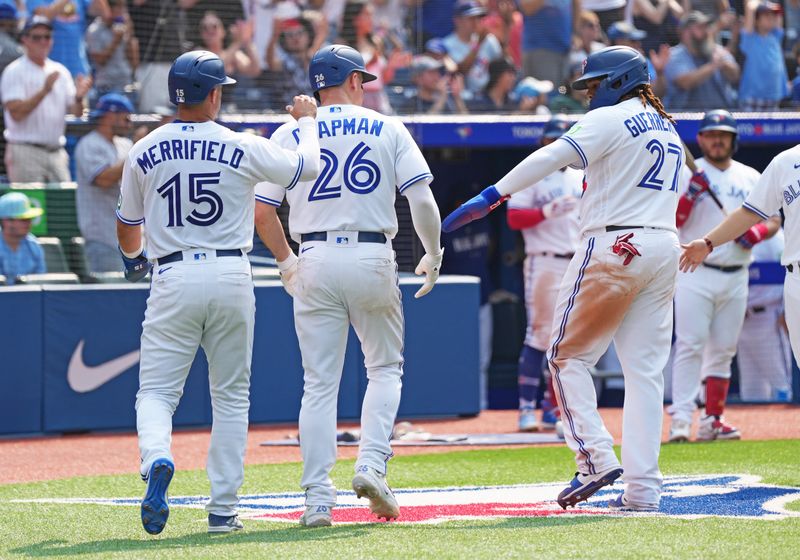 Jul 16, 2023; Toronto, Ontario, CAN; Toronto Blue Jays left fielder Whit Merrifield (15) and third baseman Matt Chapman (26) and first baseman Vladimir Guerrero Jr. (27) celebrate scoring runs against the Arizona Diamondbacks during the eighth inning at Rogers Centre. Mandatory Credit: Nick Turchiaro-USA TODAY Sports