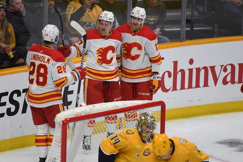 Jan 4, 2024; Nashville, Tennessee, USA; Calgary Flames center Connor Zary (47) is congratulated by teammates after a goal against Nashville Predators goaltender Juuse Saros (74) during the first period at Bridgestone Arena. Mandatory Credit: Christopher Hanewinckel-USA TODAY Sports