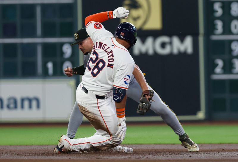 May 18, 2024; Houston, Texas, USA; Houston Astros first baseman Jon Singleton (28) is tagged out by Milwaukee Brewers shortstop Willy Adames (27) at second base trying to turn a single into a double in the second inning at Minute Maid Park. Mandatory Credit: Thomas Shea-USA TODAY Sports