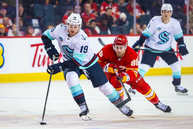 Mar 4, 2024; Calgary, Alberta, CAN; Seattle Kraken left wing Jared McCann (19) and Calgary Flames left wing Andrew Mangiapane (88) battles for the puck during the third period at Scotiabank Saddledome. Mandatory Credit: Sergei Belski-USA TODAY Sports