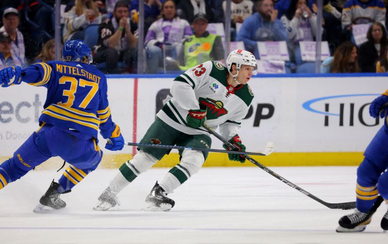 Nov 10, 2023; Buffalo, New York, USA;  Minnesota Wild center Marco Rossi (23) looks to make a pass as Buffalo Sabres center Casey Mittelstadt (37) defends during the first period at KeyBank Center. Mandatory Credit: Timothy T. Ludwig-USA TODAY Sports