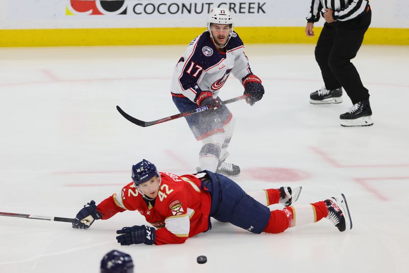 Apr 11, 2024; Sunrise, Florida, USA; Columbus Blue Jackets right wing Justin Danforth (17) passes the puck as Florida Panthers defenseman Gustav Forsling (42) defends during the first period at Amerant Bank Arena. Mandatory Credit: Sam Navarro-USA TODAY Sports