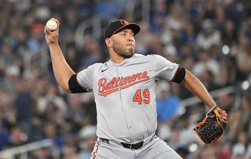 Jun 5, 2024; Toronto, Ontario, CAN;  Baltimore Orioles starting pitcher Albert Suarez (49) delivers a pitch against the Toronto Blue Jays in the first inning at Rogers Centre. Mandatory Credit: Dan Hamilton-USA TODAY Sports 