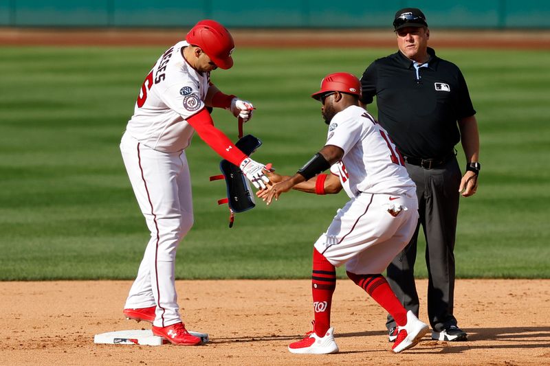 Aug 17, 2023; Washington, District of Columbia, USA; Washington Nationals designated hitter Joey Meneses (45) celebrates with Nationals first base coach Eric Young Jr. (12) after hitting a two run double against the Boston Red Sox during the fifth inning at Nationals Park. Mandatory Credit: Geoff Burke-USA TODAY Sports