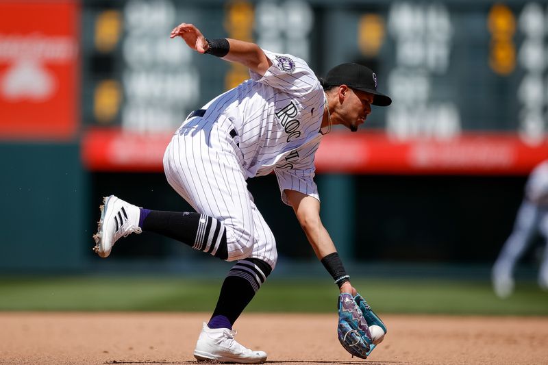 Jul 2, 2023; Denver, Colorado, USA; Colorado Rockies shortstop Ezequiel Tovar (14) fields the ball in the sixth inning against the Detroit Tigers at Coors Field. Mandatory Credit: Isaiah J. Downing-USA TODAY Sports