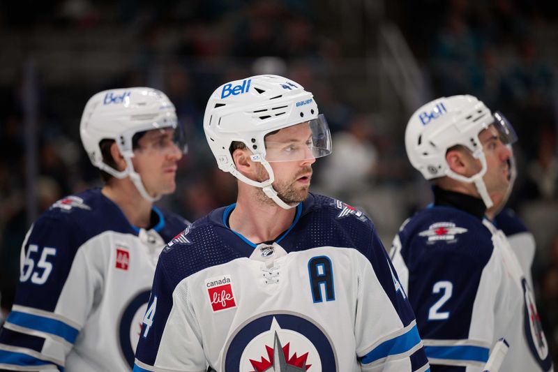 Dec 12, 2023; San Jose, California, USA; Winnipeg Jets defenseman Josh Morrissey (44) stands with center Mark Scheifele (55) and defenseman Dylan DeMelo (2) during a timeout against the San Jose Sharks in the second period at SAP Center at San Jose. Mandatory Credit: Robert Edwards-USA TODAY Sports