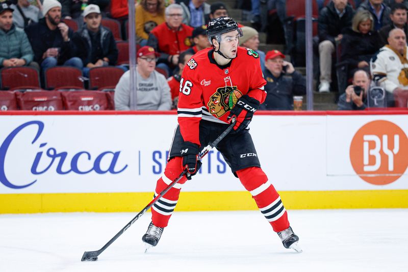 Nov 18, 2025; Chicago, Illinois, USA; Chicago Blackhawks defenseman Louis Crevier (46) looks to pass the puck against the Calgary Flames during the first period at United Center. Mandatory Credit: Kamil Krzaczynski-Imagn Images
