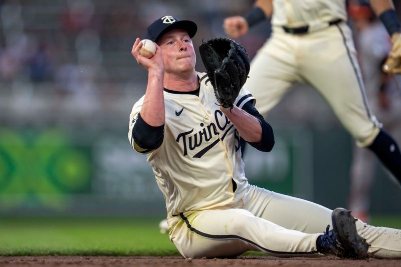 May 7, 2025; Minneapolis, Minnesota, USA; Minnesota Twins relief pitcher Louis Varland (37) throws the ball to first base from the ground after diving for a ground ball against the Baltimore Orioles in the sixth inning at Target Field. Mandatory Credit: Jesse Johnson-Imagn Images