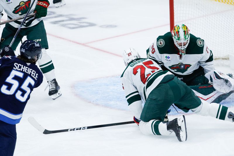 Nov 23, 2025; Winnipeg, Manitoba, CAN;  Minnesota Wild goalie Jesper Wallstedt (30) makes a save on a shot by Winnipeg Jets forward Mark Scheifele (55) during the second period at Canada Life Centre. Mandatory Credit: Terrence Lee-Imagn Images