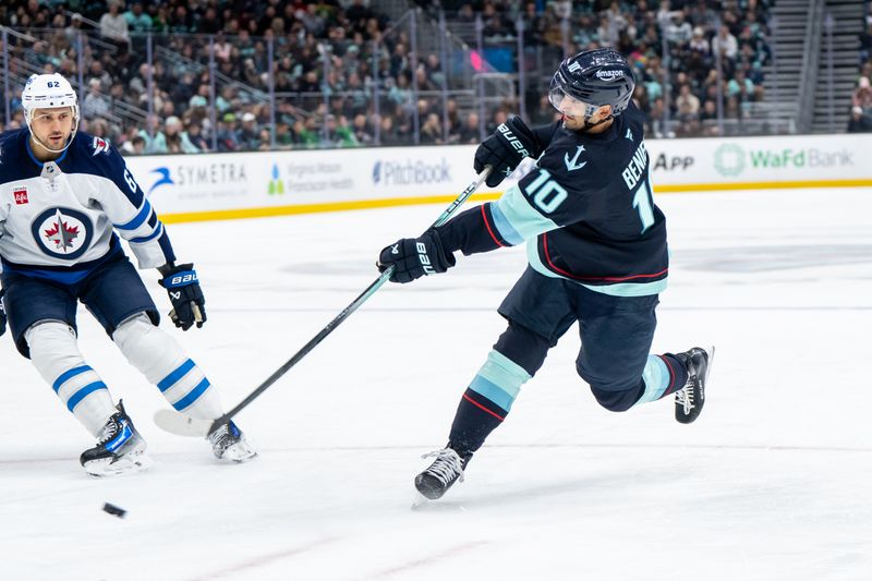 Mar 16, 2025; Seattle, Washington, USA;  Seattle Kraken forward Matty Beniers (10) takes a shot against Winnipeg Jets forward Nino Niederreiter (62) during the first period at Climate Pledge Arena. Mandatory Credit: Stephen Brashear-Imagn Images