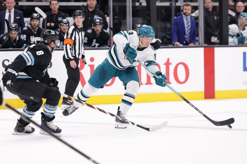 Oct 28, 2024; Salt Lake City, Utah, USA;  San Jose Sharks defenseman Henry Thrun (3) pushes the puck away from Utah Hockey Club center Nick Schmaltz (8) during the third period at Delta Center. Mandatory Credit: Chris Nicoll-Imagn Images