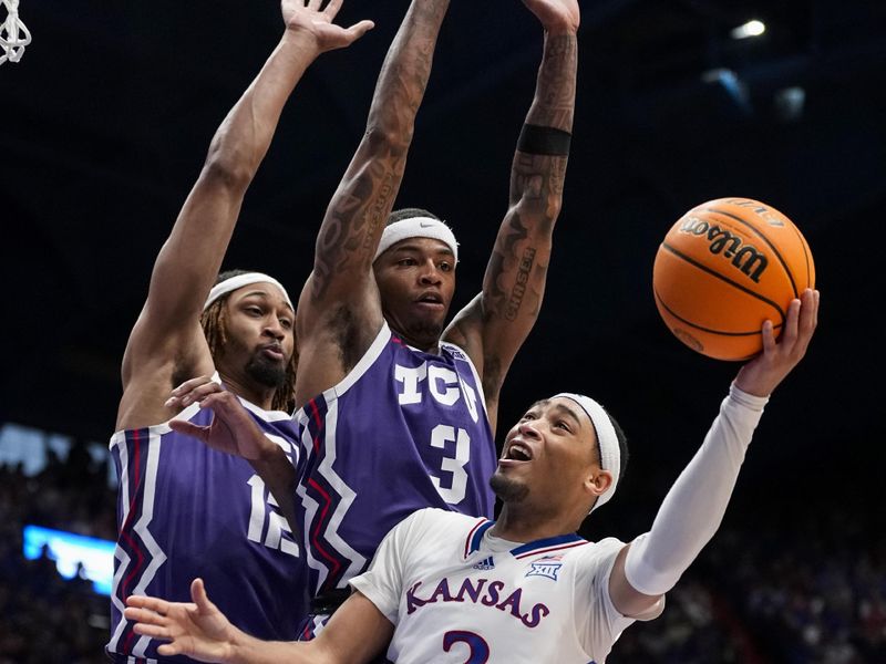 Jan 6, 2024; Lawrence, Kansas, USA; Kansas Jayhawks guard Dajuan Harris Jr. (3) shoots against TCU Horned Frogs forward Xavier Cork (12) and guard Avery Anderson III (3) during the second half at Allen Fieldhouse. Mandatory Credit: Jay Biggerstaff-USA TODAY Sports