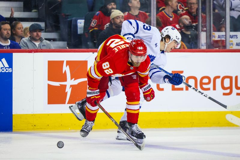 Jan 18, 2024; Calgary, Alberta, CAN; Calgary Flames defenseman Jordan Oesterle (82) and Toronto Maple Leafs left wing Matthew Knies (23) battles for the puck during the third period at Scotiabank Saddledome. Mandatory Credit: Sergei Belski-USA TODAY Sports