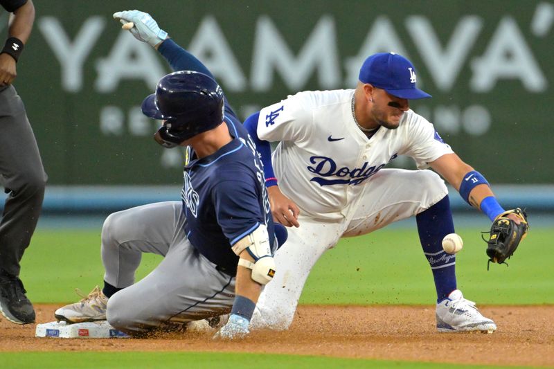 Aug 23, 2024; Los Angeles, California, USA;  Tampa Bay Rays right fielder Jonny DeLuca (21) beats the throw to Los Angeles Dodgers shortstop Miguel Rojas (11) for a double in the second inning at Dodger Stadium. Mandatory Credit: Jayne Kamin-Oncea-USA TODAY Sports