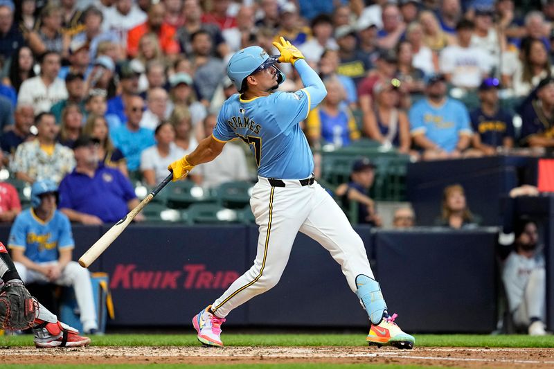 Jul 12, 2024; Milwaukee, Wisconsin, USA;  Milwaukee Brewers shortstop Willy Adames (27) hits an RBI double during the fourth inning against the Washington Nationals at American Family Field. Mandatory Credit: Jeff Hanisch-USA TODAY Sports