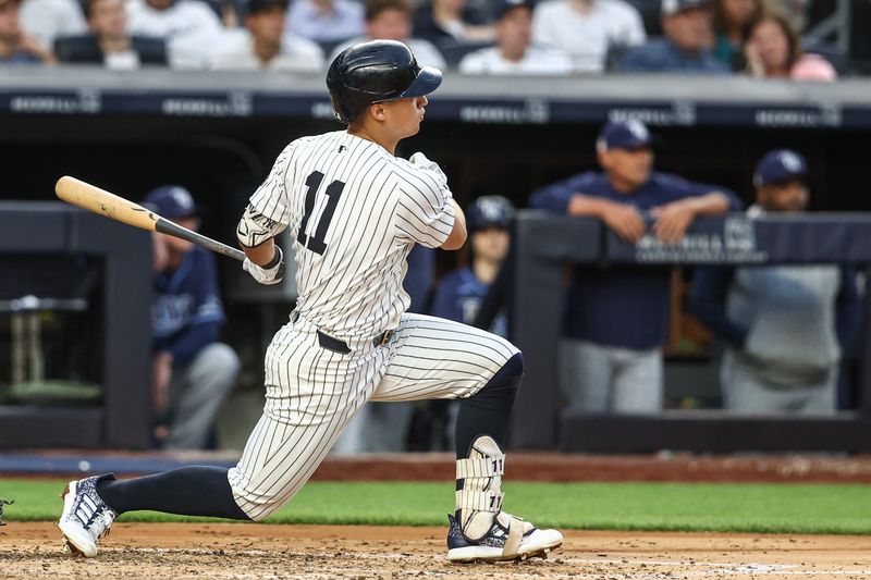 Jul 19, 2024; Bronx, New York, USA;  New York Yankees shortstop Anthony Volpe (11) hits a three run double in the third inning against the Tampa Bay Rays at Yankee Stadium. Mandatory Credit: Wendell Cruz-USA TODAY Sports