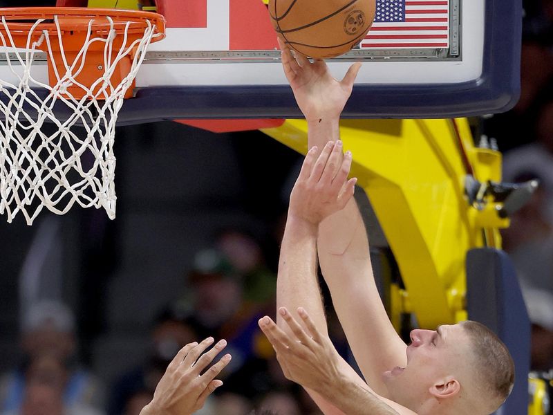 DENVER, COLORADO - NOVEMBER 08: Nikola Jokic #15 of the Denver Nuggets goes to the basket against Trayce Jackson-Davis #32 of the Golden State Warriors in the first quarter at Ball Arena on November 08, 2023 in Denver, Colorado. NOTE TO USER: User expressly acknowledges and agrees that, by downloading and or using this photograph, User is consenting to the terms and conditions of the Getty Images License Agreement.  (Photo by Matthew Stockman/Getty Images)