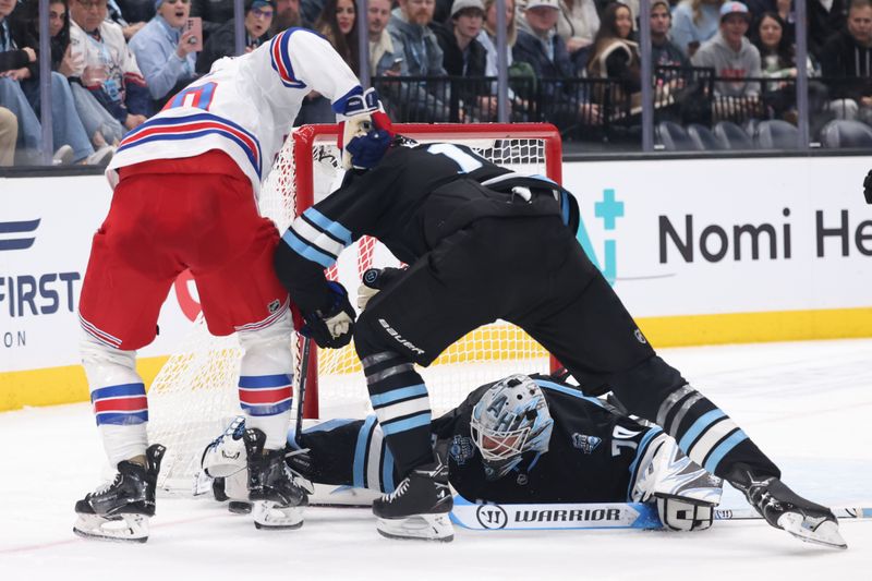 Jan 16, 2025; Salt Lake City, Utah, USA; Utah Hockey Club goaltender Karel Vejmelka (70) grabs the puck against the New York Rangers during the third period at Delta Center. Mandatory Credit: Rob Gray-Imagn Images