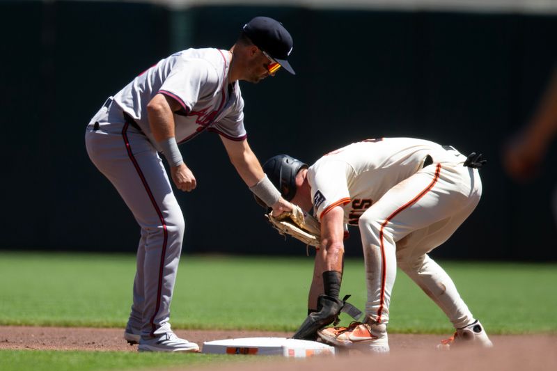 Aug 15, 2024; San Francisco, California, USA; Atlanta Braves shortstop Orlando Arcia (11) applies the tag too late to San Francisco Giants shortstop Tyler Fitzgerald (49) as he steals second during the first inning at Oracle Park. Mandatory Credit: D. Ross Cameron-USA TODAY Sports