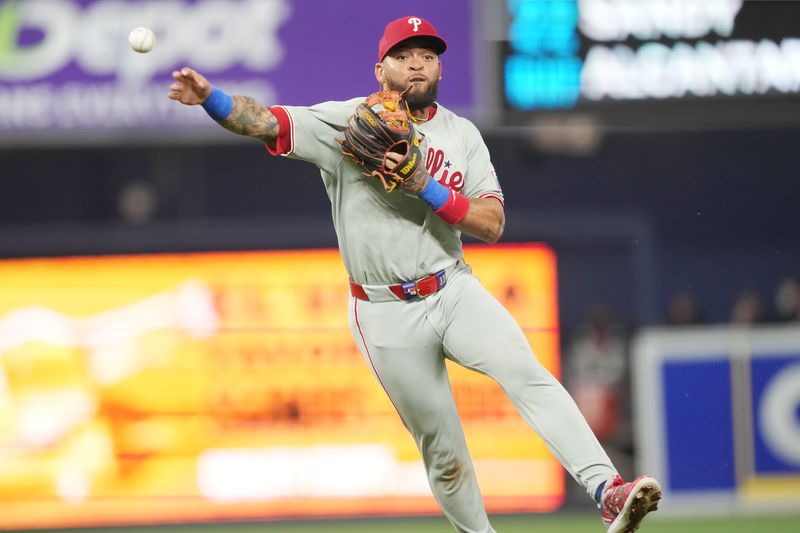 Sep 6, 2025; Miami, Florida, USA;  Philadelphia Phillies shortstop Edmundo Sosa (33) tries to throw out Miami Marlins third baseman Javier Sanoja in the fourth inning at loanDepot Park. Mandatory Credit: Jim Rassol-Imagn Images