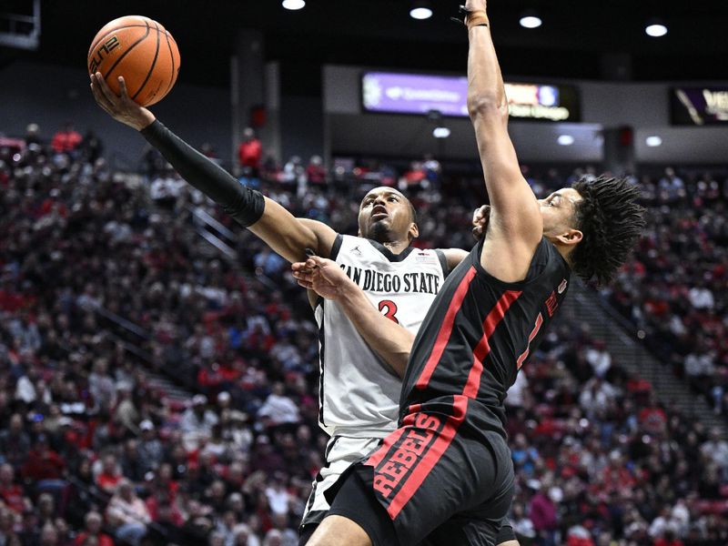 Jan 6, 2024; San Diego, California, USA; San Diego State Aztecs guard Micah Parrish (3) is fouled while going to the basket against UNLV Rebels forward Jalen Hill (1) during the first half at Viejas Arena. Mandatory Credit: Orlando Ramirez-USA TODAY Sports