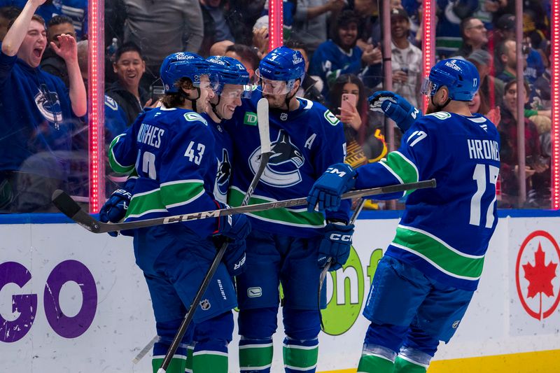 Nov 14, 2024; Vancouver, British Columbia, CAN; Vancouver Canucks forward Jonathan Lekkerimaki (23) and defenseman Quinn Hughes (43) and forward J.T. Miller (9) and defenseman Filip Hronek (17) celebrate Lekkerimaki’s first ever NHL goal against the New York Islanders during the first period at Rogers Arena. Mandatory Credit: Bob Frid-Imagn Images